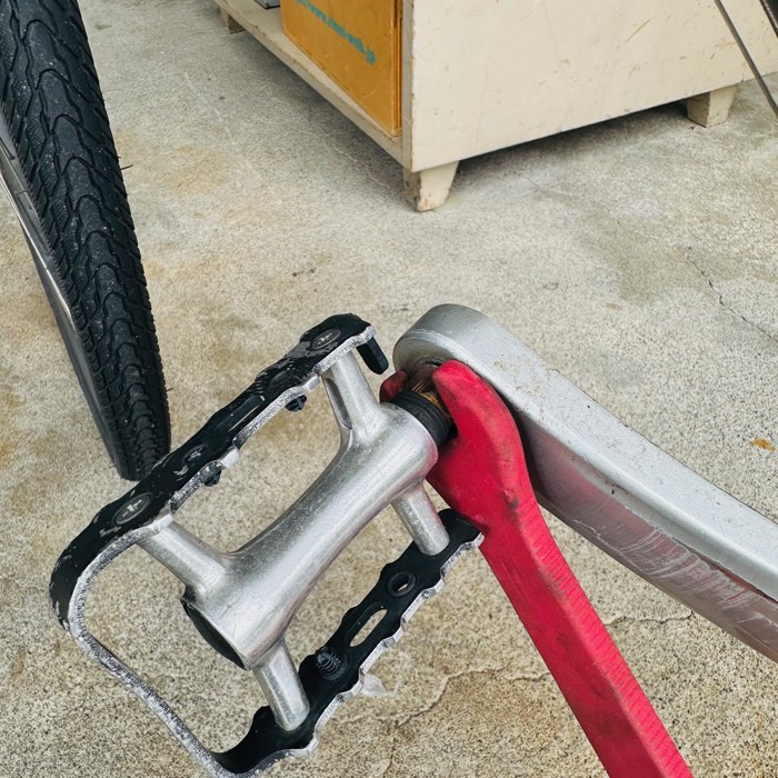 薄口のペダルレンチで古いペダルを取り外す作業