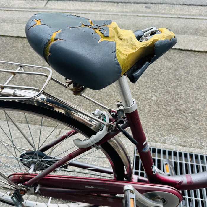 カバーが破れてクッションが露出した交換前の自転車サドル