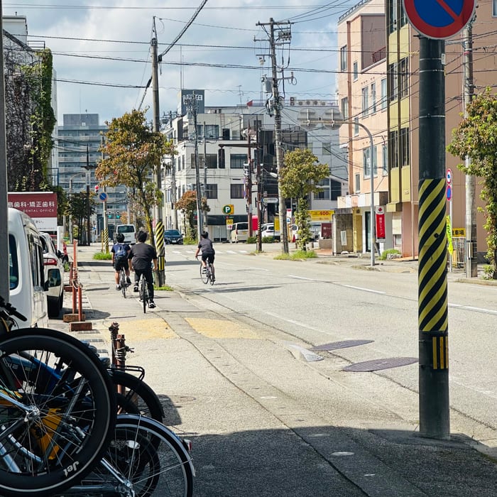 晴れた富山の街へレンタサイクルで走り出す利用者たち