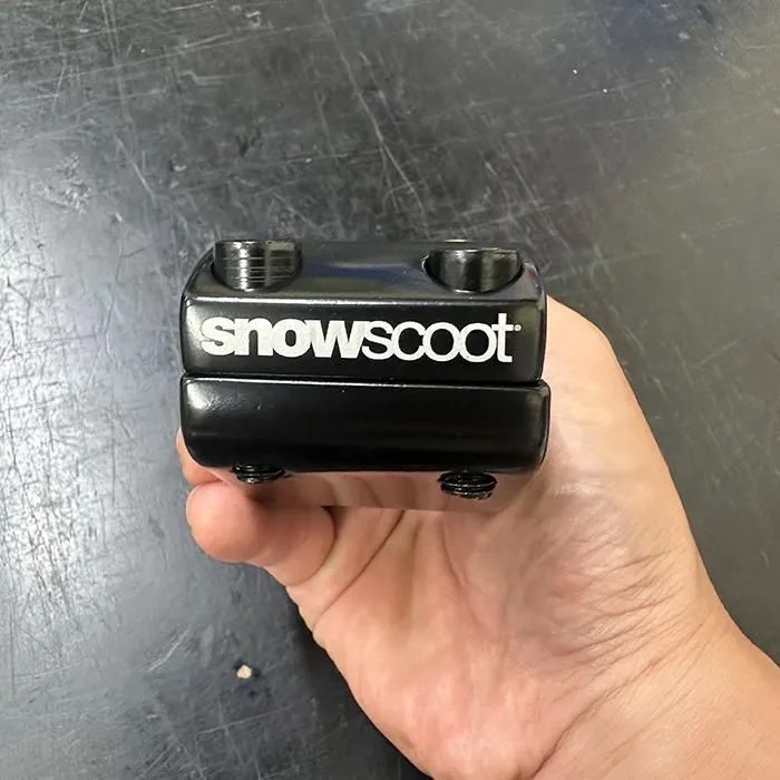 手に持ったJYKKステムとSNOWSCOOTロゴ