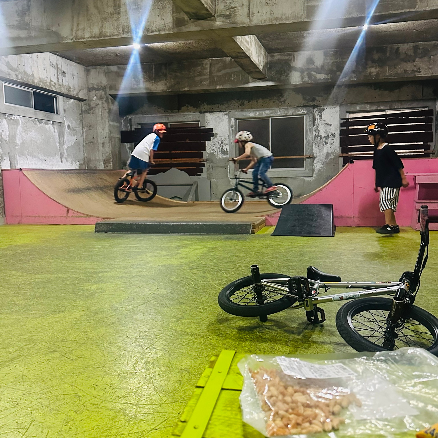 室内パークのランプでBMXに乗って練習する様子